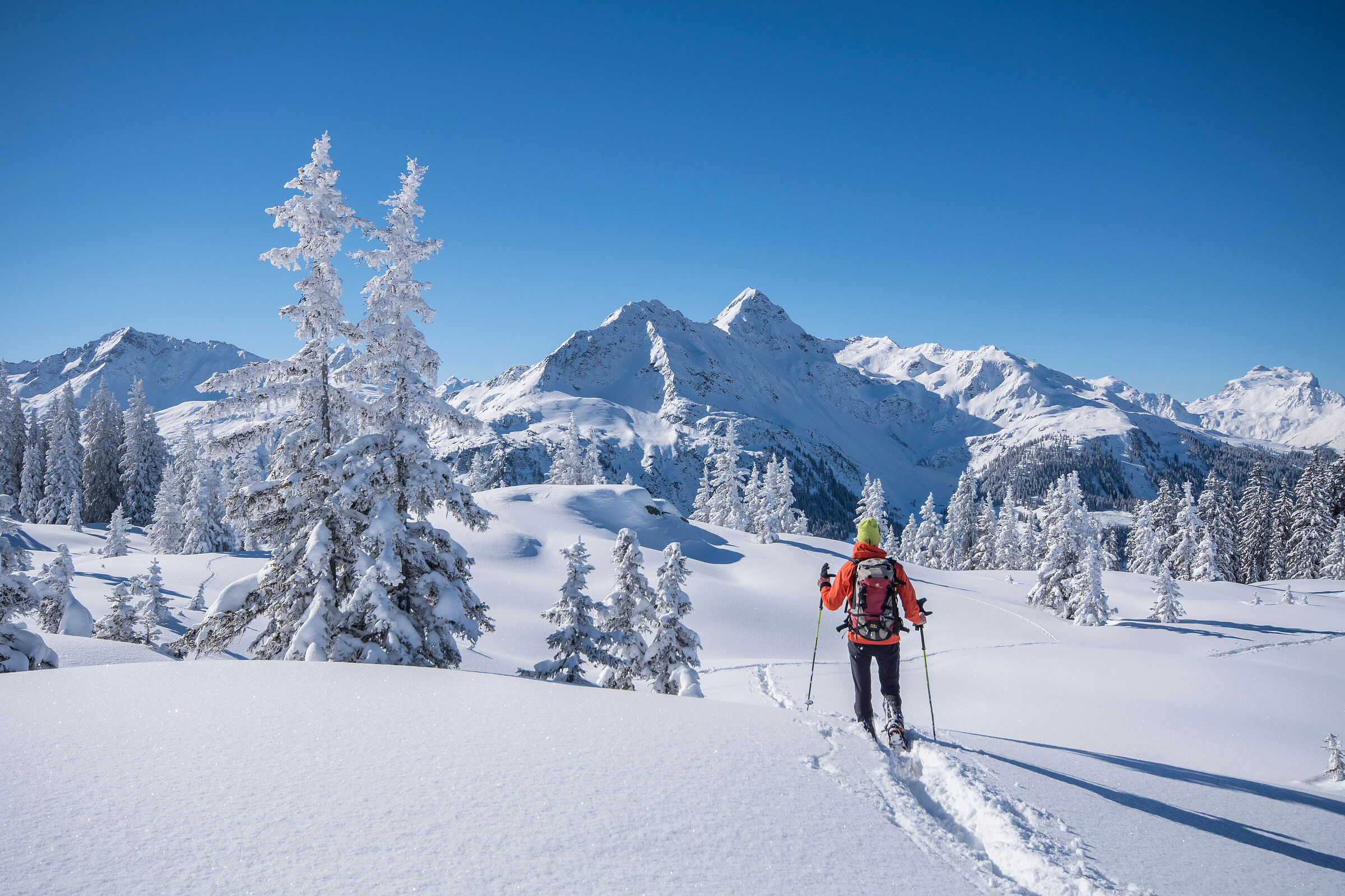 Es gibt Alternativen: Wintersportarten wie das Wandern mit Schneeschuhen oder Tourenskiern schonen die Natur. (Foto: Netzer-Johannes- stock.adobe.com) Beispiel für sanften Alpentourismus: Winterwanderer in verschneiter Landschaft vor sonnenbeschienenem Gipfel