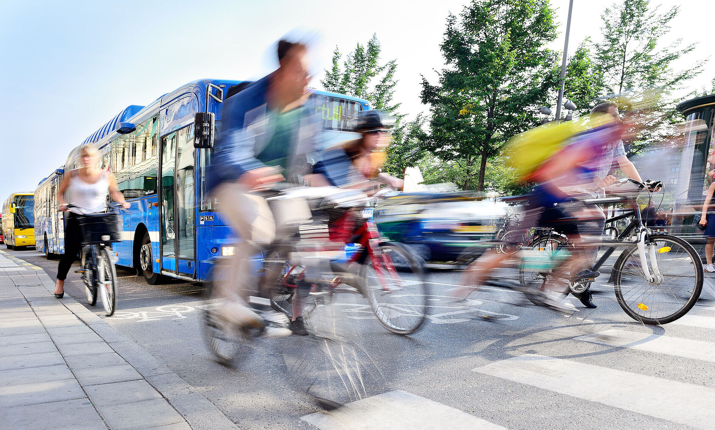 Der BUND Naturschutz setzt sich für die Verkehrswende ein - im Sinne des Klimaschutzes sowie einer gesünderen und lebenswerteren Zukunft (Foto: connel design/stock.adobe.com). Eine Gruppe Radfahrer startet an der Ampel vor einem Bus (Foto: cooel_design/stock.adobe.com)