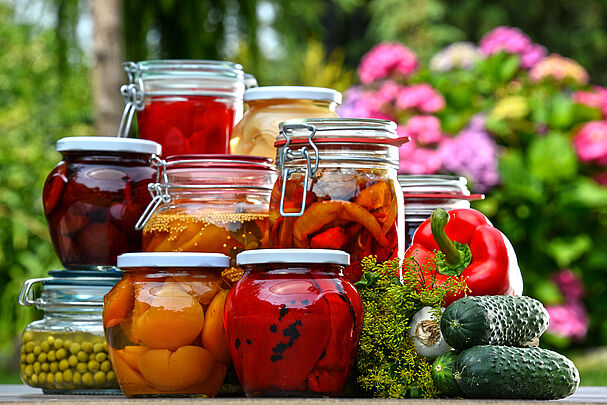 Gläser voll eingelegtem Gemüse und Obst im Garten (Foto: monticello/stock.adobe.com)